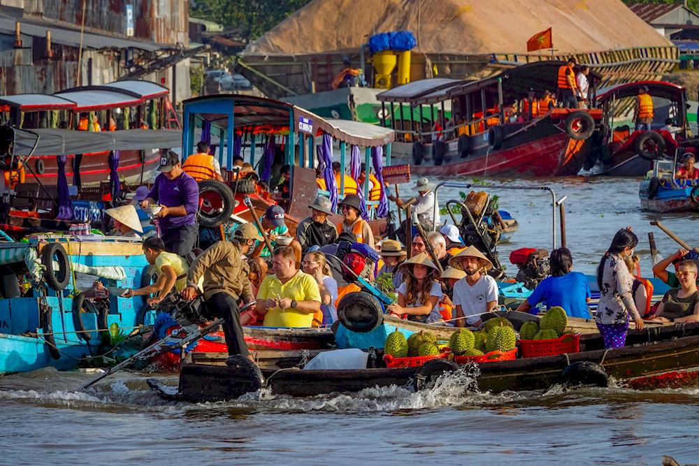 Cai Rang Floating Market bursts to life at dawn, with boats piled high with fruits, local treats, and the vibrant rhythm of river trade in the Mekong Deltav